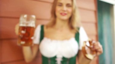 Seksi bir genç bayan Almanya'da bir bira festivalinde bira içiyor. Yakın çekim, büyük bira bardağı, gülen bir kız neşeyle, kırmızı dudaklar, beyaz dişli gülümseyin