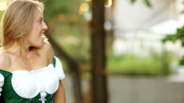 Geleneksel Bavyera elbiseli bir kız bir bardak bira bira festivali Oktoberfest barmen arasında geçen süredir. Kadın mutlu ve gülüyor, sürpriz ve neşeli bir kız. Açık Hava