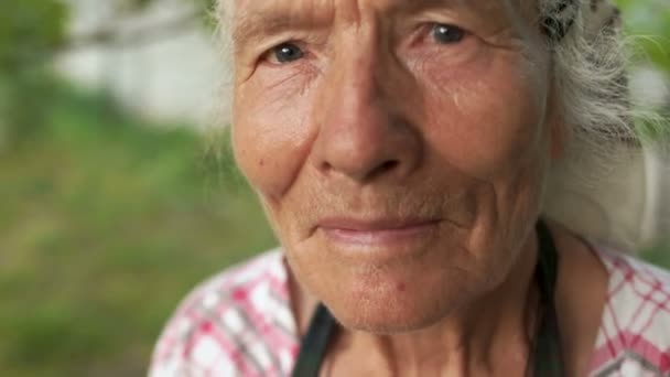 Porträt einer sehr alten Frau mit einem Tuch auf dem Kopf, ihre Lippen sagen ein Wort, flüstern — Stockvideo