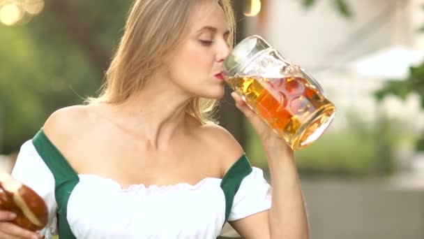 Festival de la cerveza Oktoberfest. Mujer madura en un traje bávaro tradicional bebiendo cerveza en grandes tragos codiciosamente. Divertido ríe con felicidad. Viajes y nuevas experiencias — Vídeos de Stock