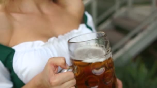 Un vaso de cerveza alemana fría y espumosa en manos de una hermosa chica en el festival Oktoberfest en Munich, Baviera — Vídeos de Stock