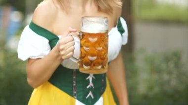 Parlak genç garson onun ellerinde Alman bira bir kupa ile ulusal Bavyera elbiseli bir reverans yay yapar ve neşeyle gülüyor. Oktoberfest bira festivali