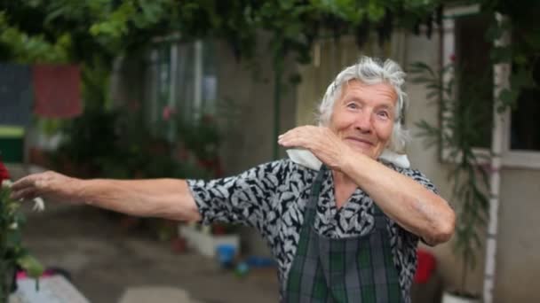 Una jubilada alegre en una bufanda está bailando un poco. La abuela se ríe. Cultura juvenil moderna, cultura rap, baile debe. Sentido del humor — Vídeos de Stock