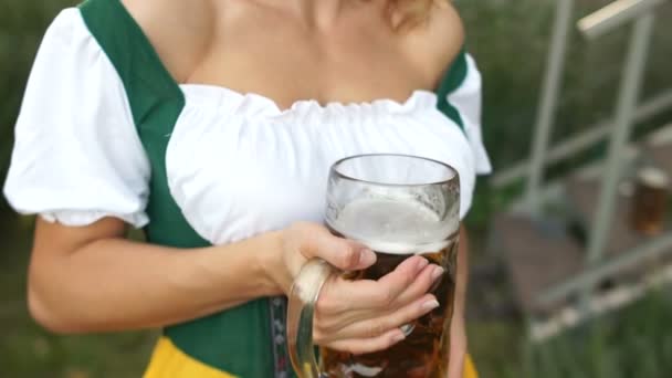 Un traje tradicional bávaro en una camarera durante el festival Oktoberfest. Vista seductora de un decolete de mujeres y un vaso de cerveza — Vídeos de Stock