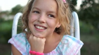 Gülümseyen ve kameraya bakarken gülüyor güzel sevimli blondy beyaz küçük kız closeup portresi. Gerçek zamanlı tam hd video görüntüleri