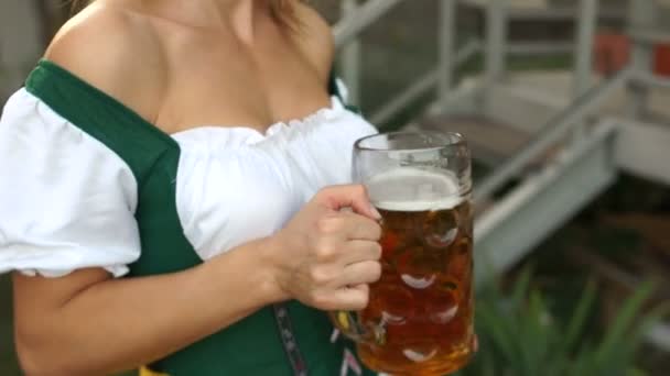 Сексуальная горячая официантка несёт пиво возле своей большой груди. Размытое видео. Октоберфест — стоковое видео
