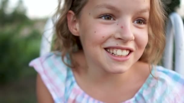 Mooie schoolmeisje glimlacht in al haar mond. een mooi meisje, een nauwe zomer portret. Gezonde levensstijl, zomer-vakantie, reizen — Stockvideo