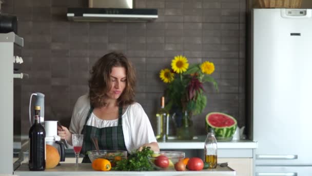 Chica alegre baila durante la preparación de la cena. Cocina casera, día de las madres, comida saludable, ama de casa en la cocina — Vídeos de Stock