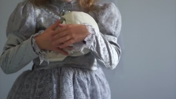 Girl dressed as a dracula bride is holding a one-eyed skull. Gray color range. Day of the dead, hallowen — Stock Video