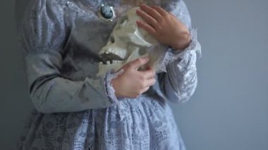 Kız bir cadı kostüm konturlar ve tek gözlü bebek kafatası gibi sallıyor. Tatil Halloween, tüm azizler günü. Yaratıcı renkleri