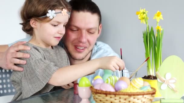 Feliz Natal de família. Pai e filha pintam ovos de Páscoa para cesta de Páscoa — Vídeo de Stock