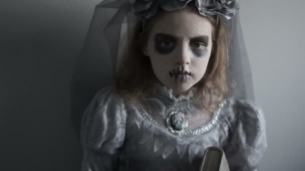 Portret voor Halloween. Portret van een meisje in de samenstelling van een dode man sluit. Wit gezicht, zwarte cirkels rond de ogen, zwarte lippen. Creatieve viering van de dag van de dood, koude kleuren — Stockvideo