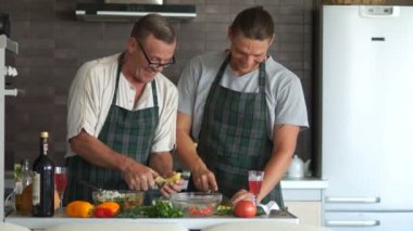 Yetişkin baba ve oğul birlikte mutfakta yemek. mutlu aile, babalar günü, erkek ilişkileri