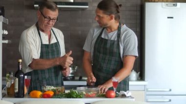 Sağlıklı gıda, vejetaryenlik. Yetişkin baba ve oğul birlikte mutfakta yemek. mutlu aile, babalar günü, erkek ilişkileri