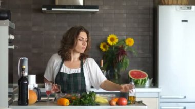 Mutfakta dans çekici kıvırcık genç kadın. Zeytinyağlı salata salata. Sağlıklı gıda, vejetaryenlik