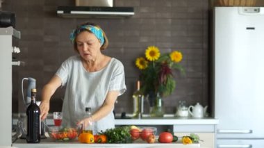 Mutfakta yaşlı emekli bir salata hazırlar ve bitkisel yağ ile doldurur. Sağlıklı gıda, bir yaşam biçimi olarak vejetaryenlik
