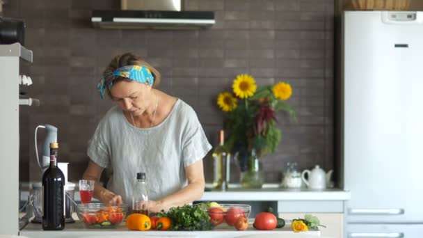 Mutfakta olgun vejetaryen bir salata hazırlar ve bitkisel yağ ile doldurur. Sağlıklı yemek yeme, bir yaşam tarzı, anneler günü, mutlu bir aile olarak vejetaryenlik — Stok video
