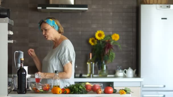 Felicità anziana donna bionda in cucina con bicchieri, vino rosso — Video Stock