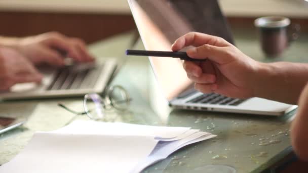 Gros plan mains et ordinateurs portables. Un homme dessine un schéma, en s'appuyant sur le papier, la formation de collègues, le transfert d'expérience, le coaching. Deux hommes serrant la main — Video