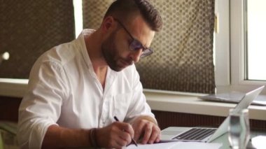 Proje, rapor teslimini tamamlanması. Beyaz bir gömlek ve gözlük bir erkekte gazetelerde bir ögeyi grev ve kabartmalı gözlüklerini kapalı alır. İş kavramı, zaman yönetimi