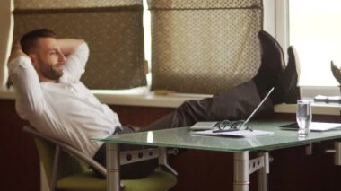 Patron gün. Office hiyerarşi, amiri. Beyaz gömlek ve Gözlük Genç kendine güvenen erkek iş adamı bacaklarını masanın üzerine atar. Zaman dinlenme, çalışma, kahve molası kır