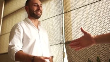 Ofiste iş görüşmesi. Karşılıklı iki iş arkadaşları meslektaşlarının. Klasik beyaz gömlekli bir adam geniş gülümsüyor. Alt görünümü. İş kavramı