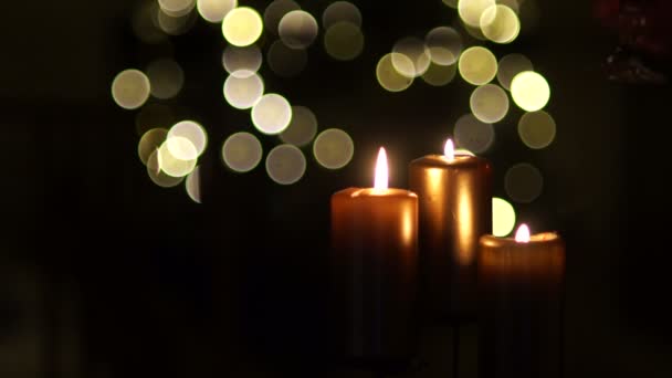 Deux verres avec du vin rouge dans les mains, les deux célèbrent Noël, une réunion romantique de nuit, la Saint-Valentin, une alliance à son doigt. Gros plan de trois bougies sur un fond sombre avec des lumières — Video