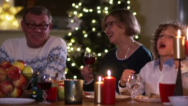 Mulher feliz no círculo familiar na mesa de Natal. Grande família no Dia de Acção de Graças. Iluminação noturna, velas na mesa — Vídeo de Stock