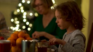 Teen yavaşça bıçak ve çatal ile yiyor. Aile Noel yemeği. Bir görgü kuralı, masada davranış kuralları. Romantik bir akşam yemeği