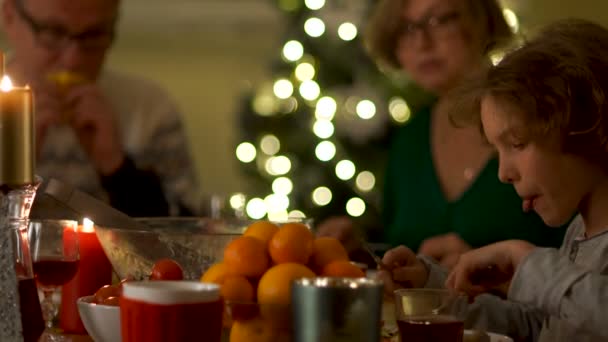 祖父、祖母、息子と孫は、クリスマスのテーブルで座ってを食べる。感謝祭は、幸せな家族。明けましておめでとう — ストック動画