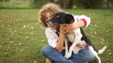 Genç köpeğiyle oynuyor. Hayvan onu yanağından itiyor. Çocuk clings için çürük yeri ve katlanmış acıyor