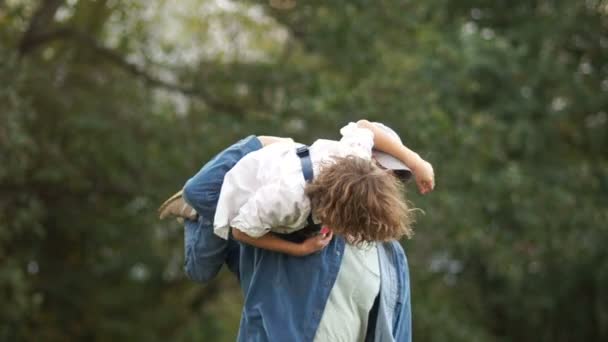 День отца Мужчина кружит на плече своего сына школьник. Выходные, здоровый образ жизни — стоковое видео