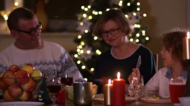 Büyük aile kutlama Noel evde çocukları ile. Şömine ve Xmas ağacı şenlikli yemekte. Ebeveyn ve çocuklar ateş yeme dekore edilmiş odaya yerleştirin. Çocuk aydınlatma advent çelenk mum