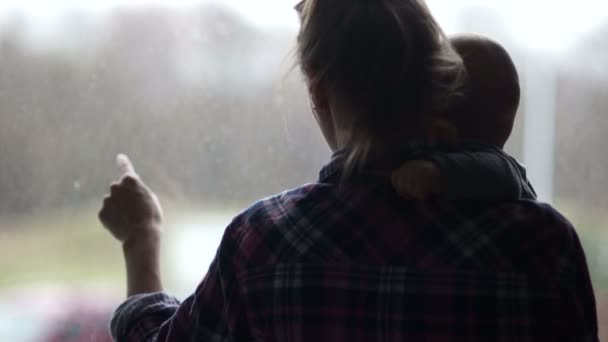 Anne ve çocuğun pencerenin karşısında rakamlar. Bir kadın pencerenin dışındaki dünya bebek gösterilmektedir. Eksik Aile, tek anne — Stok video