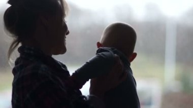 Olgun bekar anne bebeğini kucağında pencerenin ayakta tutan. IVF, kavram annelik