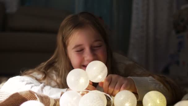 Teenie-Mädchen spielen mit leuchtenden Weihnachtskugeln. Silvester, Weihnachtsfeiertage — Stockvideo