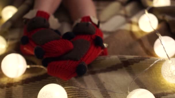 ニット ソックスで足をぴくぴく動くこと子供のクローズ アップ 創造的なクリスマスの装飾 サンタ鹿 — ストック動画