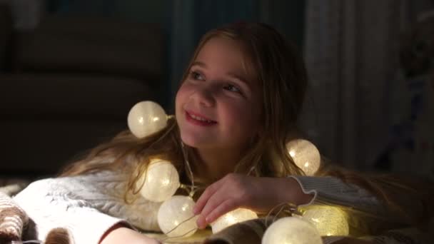 Nahes Porträt einer langhaarigen Schülerin in Erwartung eines Neujahrswunders. Heiligabend, Illumination und Dekoration — Stockvideo