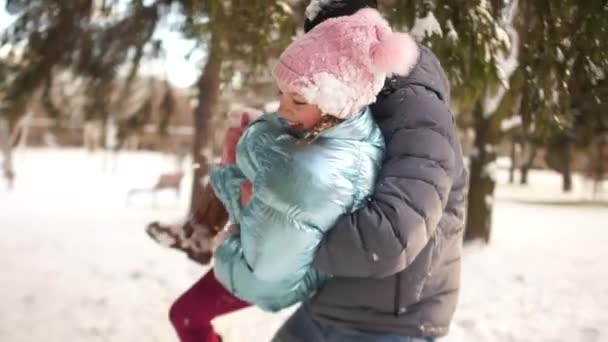 Pelea de bolas de nieve: padre e hija se divierten juntos en la nieve. Chica y hombre adulto todo en la nieve y riendo alegremente — Vídeos de Stock