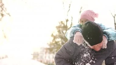 Bir kış Parkta oynayan bir çocuk olan bir adam. Kız onun babaları arka oturma ve neşeyle gülerek, Güneş parlamayı, yakın portre, babalar günü