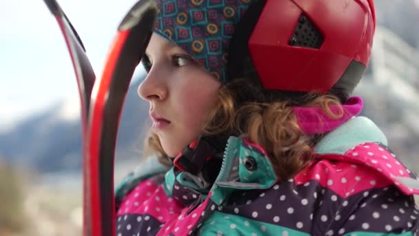 스키 장비와 헬멧에 여자의 초상화를 닫습니다. 하이 틴 스키 리프트 오두막에 상승. 여자는 심각한 표정 — 비디오