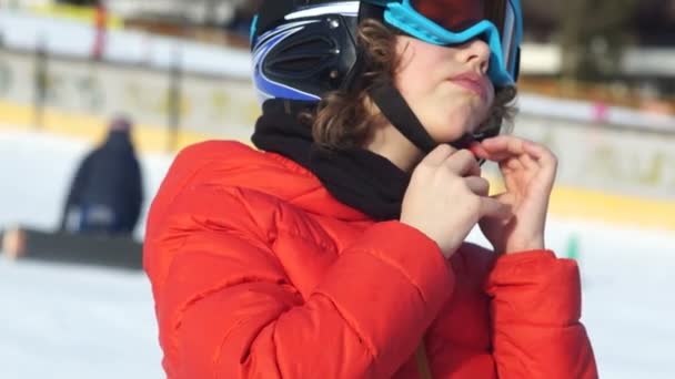 헬멧에는 스키장에서 고글 십 대 소년. 어린이 헬멧, 스키 안전, 가까운 초상화와 그의 벨트를 건다 — 비디오