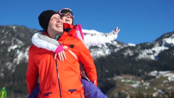 男人和女人在山里休息 女孩跳到一个男人的肩膀上 滑雪夹克和设备 — 图库视频影像