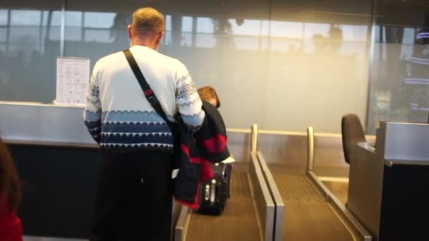 机场内的航空公司乘客 一名男子在机场办理登机手续 托运行李的后视 — 图库视频影像