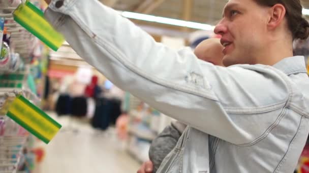 Father man buys his kid a toy. The child rejoices and pulls a hand to purchase. Fathers day — Stockvideo