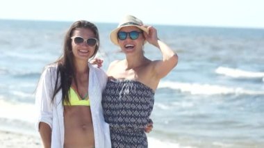 Bikini ve yazlık elbise ve güneş gözlüğü sahil üzerinde iki kadın portresi. Yaz tatili, sıcak ülkelere seyahat