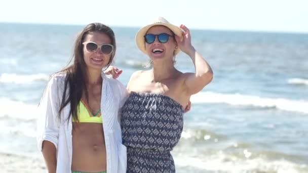 Két nő a bikini és a nyári ruha és a napszemüveg a tengerparton portréja. Nyaralás, utazás, a meleg országokban — Stock videók