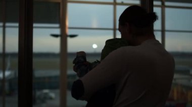 Siluetleri baba ve oğlu uçakları izlememiz arıyorum. Sürpriz çocuk Görünüşe göre baba el ile nasıl uçak çıkartıyor gösterir. Çocuklar geliştirme