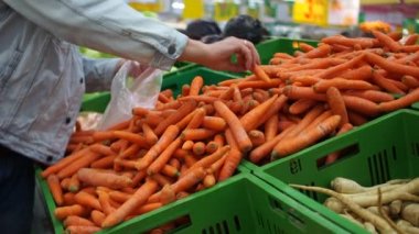 El almak havuç raf mağaza mans ve süpermarket arabası koyar. sağlıklı gıda. Alışveriş kavramı