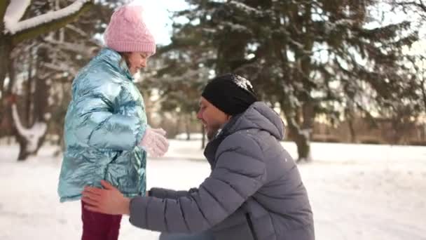 Apja rázza a lánya ruháit egy téli Park snow csata után. Apák napja — Stock videók